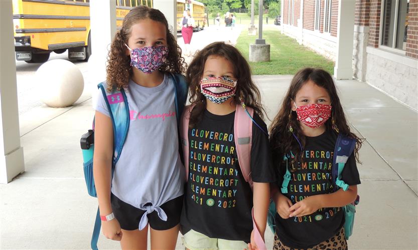 Three students smile